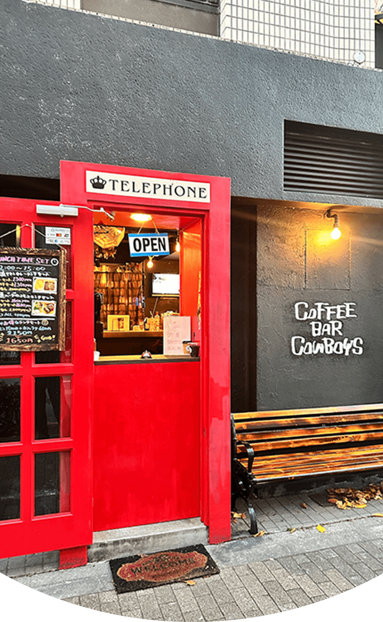 Coffee Bar Cowboysの店舗外観。赤い電話ボックスを模した特徴的な入り口とランチメニューの看板